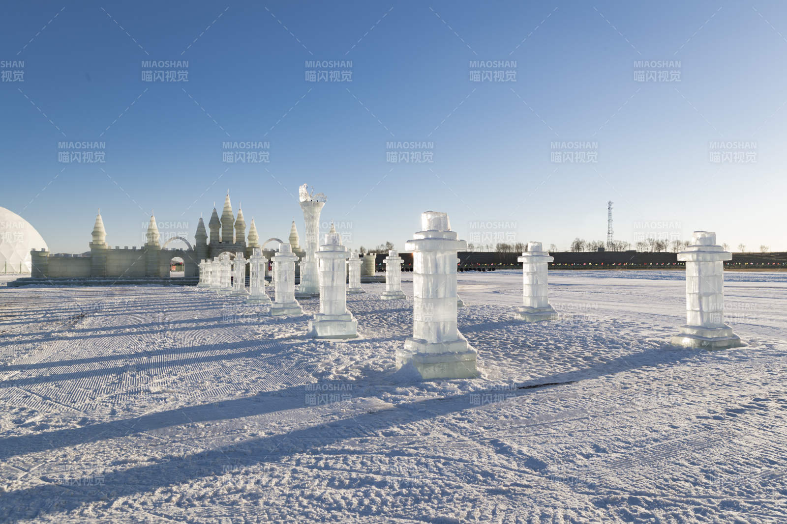 夕阳下雪原上晶莹剔透的冰雕建筑