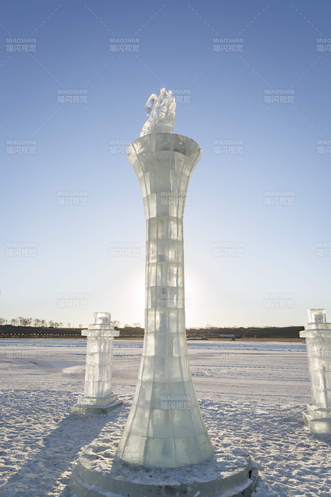 夕阳下雪原上晶莹剔透的冰雕建筑