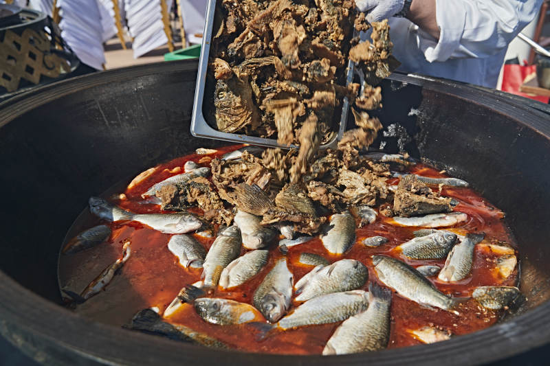 户外柴火铁锅炖煮的刚捕捞的野生鱼汤