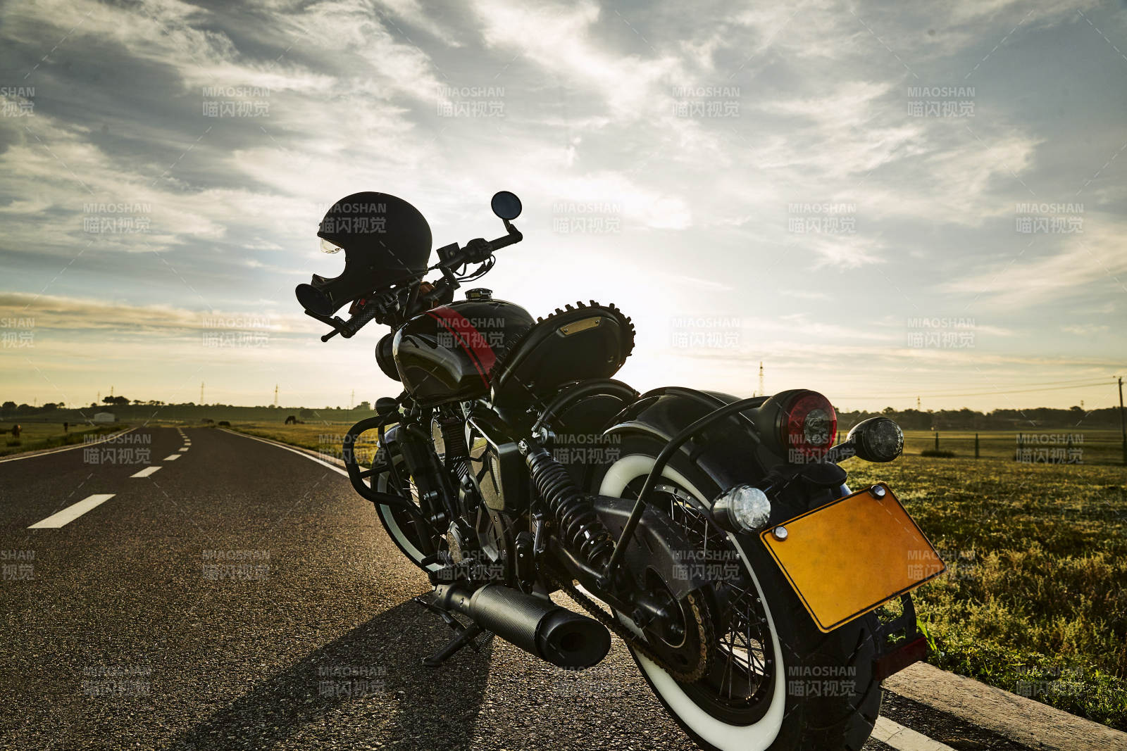 清晨朝阳下停靠在公路上的复古摩托车