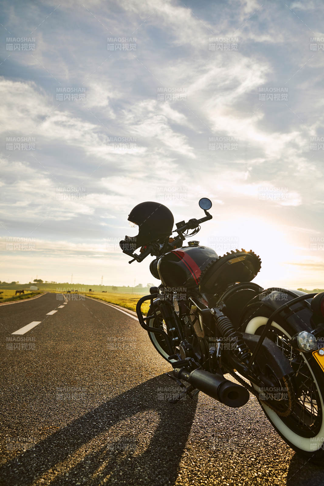 清晨朝阳下停靠在公路上的复古摩托车