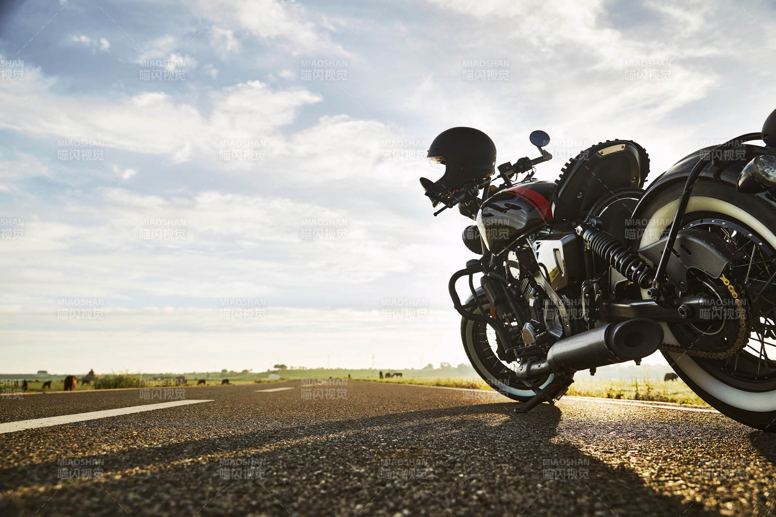 清晨朝阳下停靠在公路上的复古摩托车