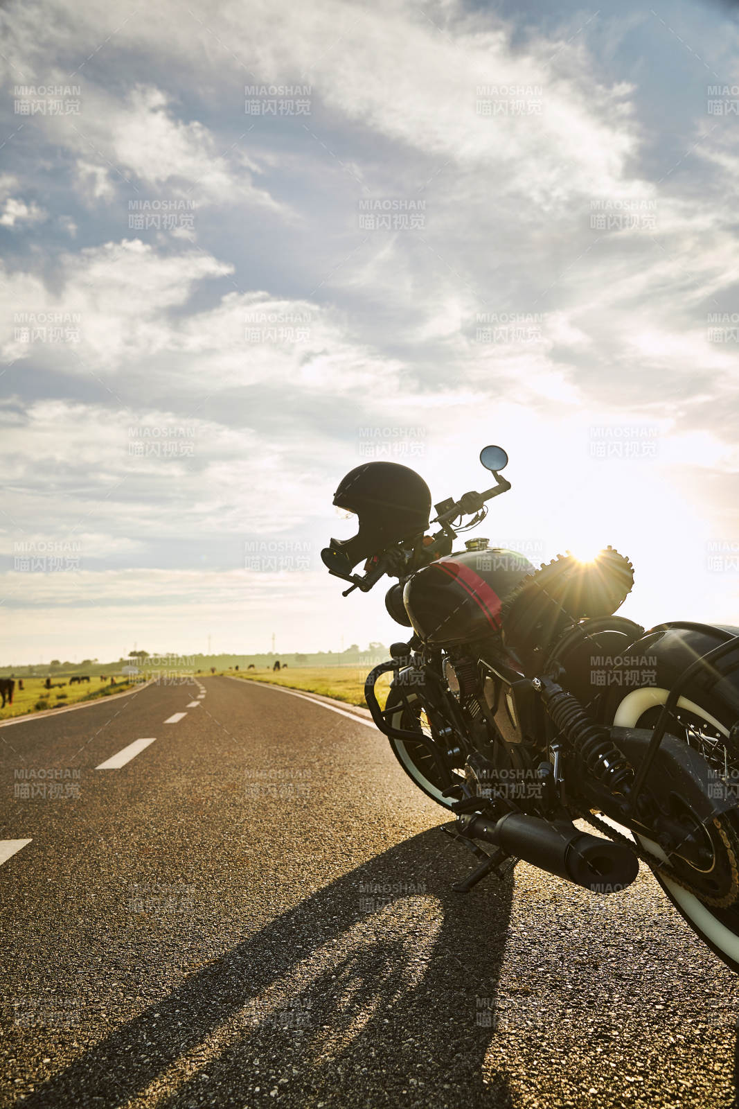 清晨朝阳下停靠在公路上的复古摩托车