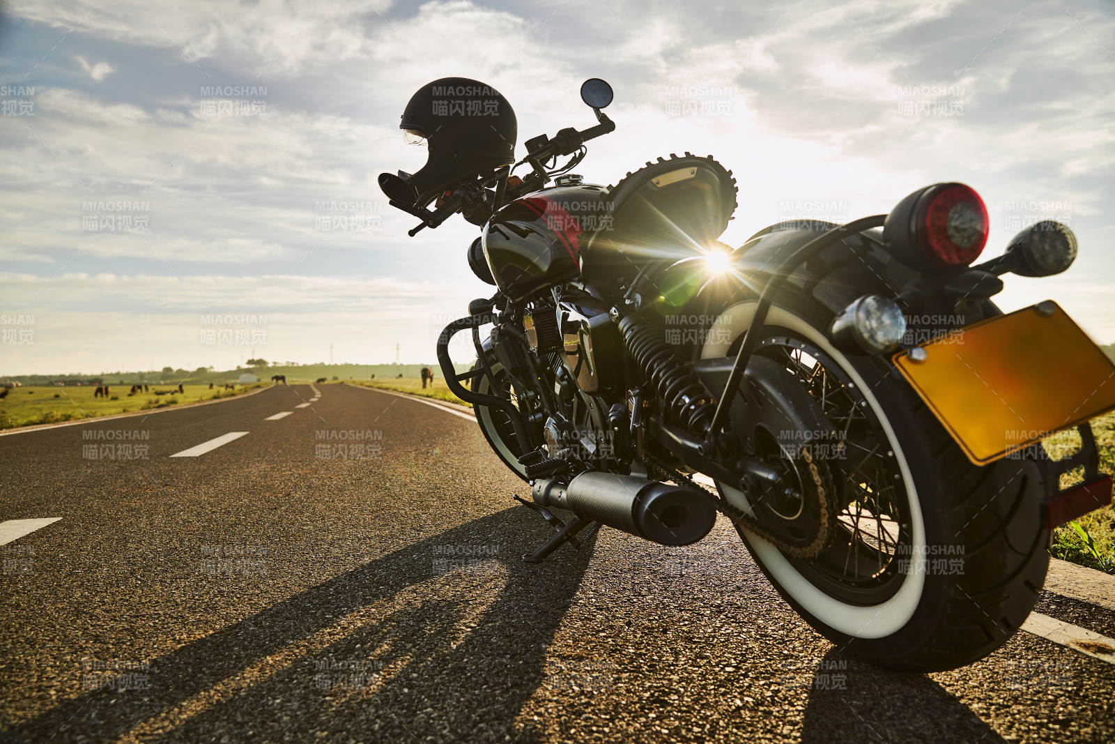 清晨朝阳下停靠在公路上的复古摩托车