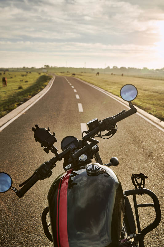 清晨朝阳下停靠在公路上的复古摩托车