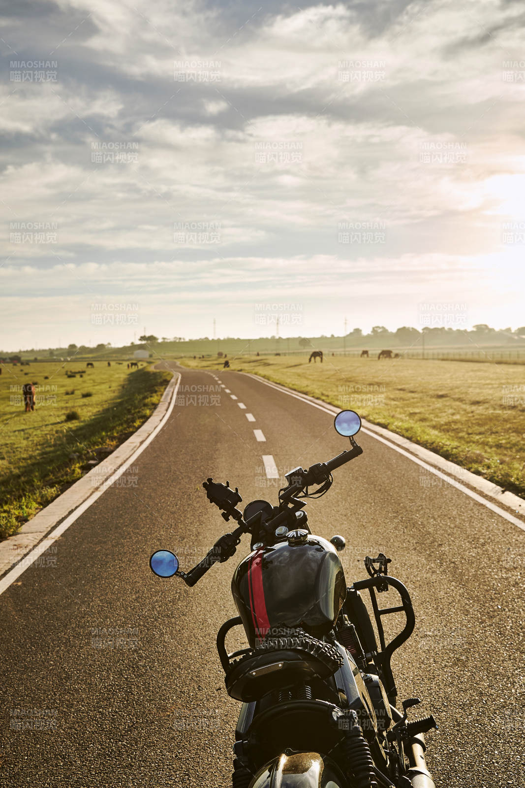 清晨朝阳下停靠在公路上的复古摩托车