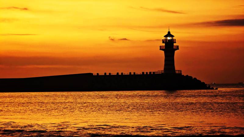 海南三亚清水湾朝霞满天中的自由灯塔剪影