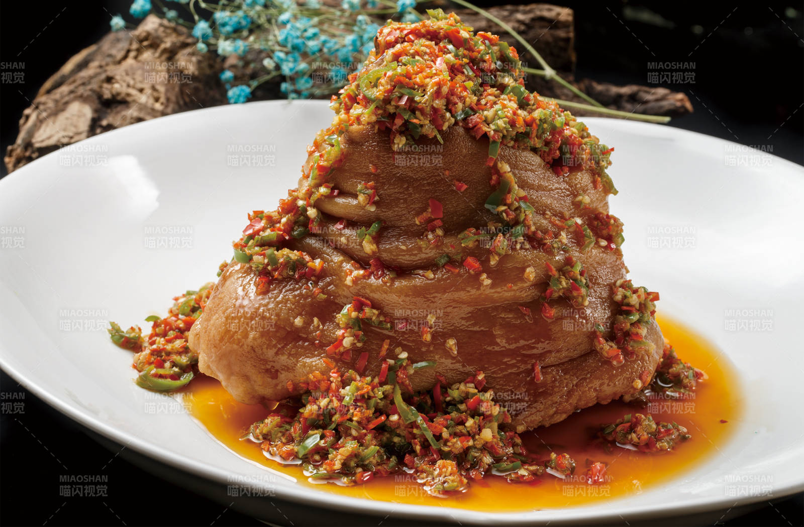 圆形白色瓷盘装的椒麻红烧猪肘