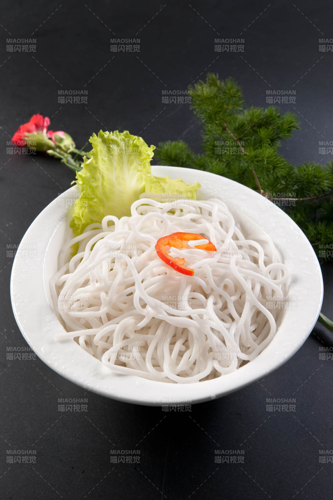 青色瓷盘装的火锅食材红薯粉条图片