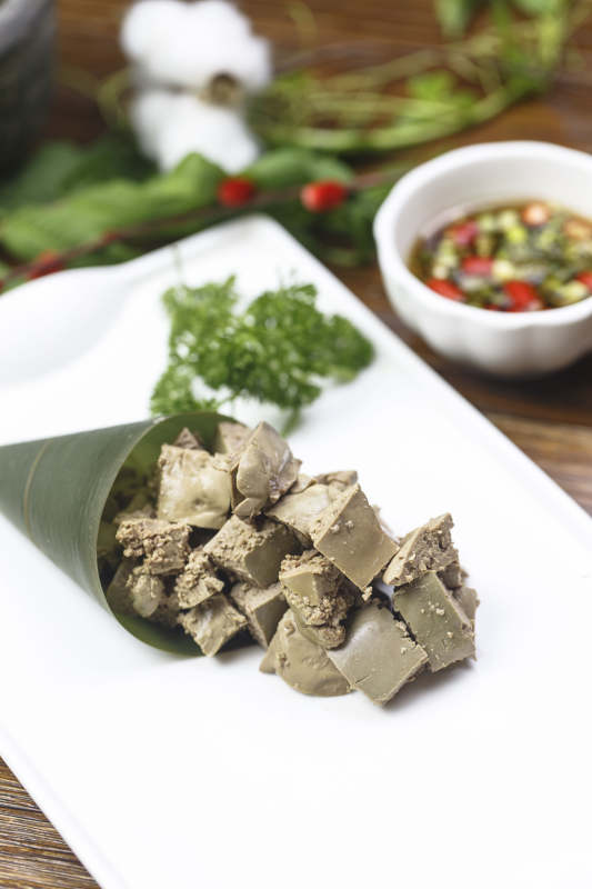 长方形白瓷盘装的蘸汁猪肝