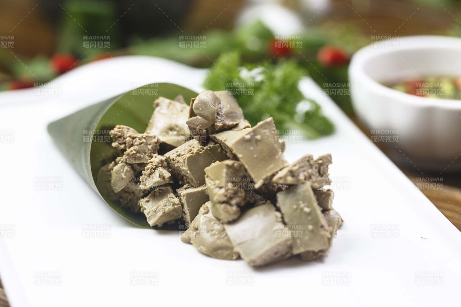 长方形白瓷盘装的蘸汁猪肝