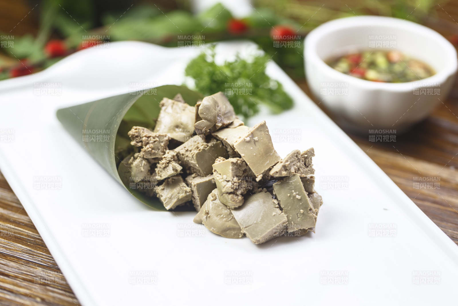 长方形白瓷盘装的蘸汁猪肝