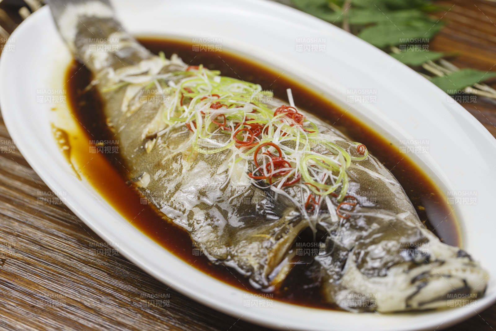 椭圆形白瓷盘装的清蒸偏口鱼左口鱼图片