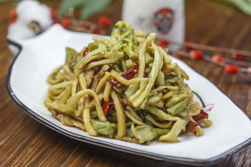 形白瓷盤裝的五花肉炒貢菜