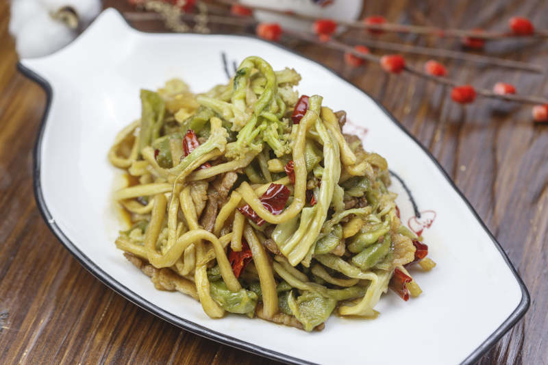 形白瓷盤裝的五花肉炒貢菜