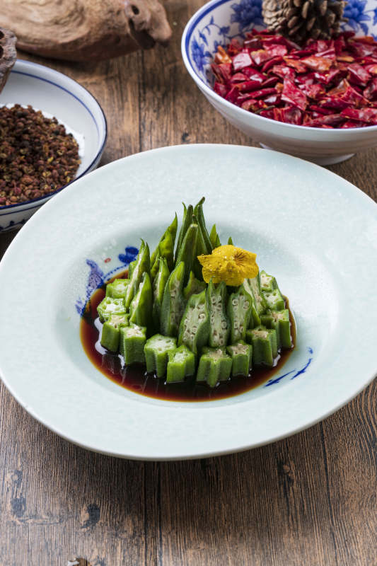 長方形白瓷盤裝的澆汁涼拌秋葵