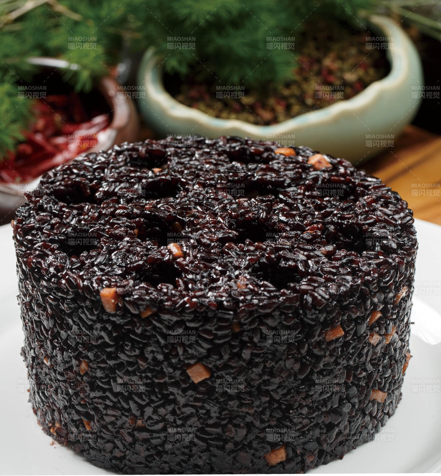 白色圆瓷盘装的蜂窝煤造型的黑米饭团