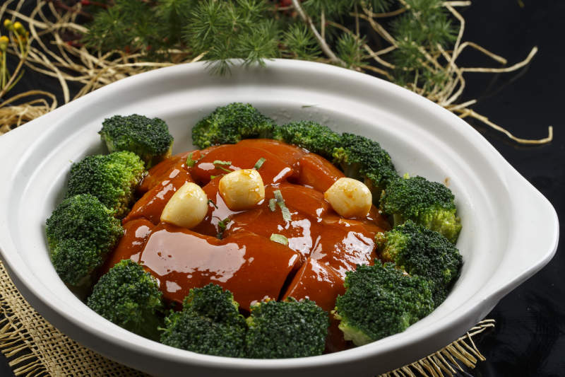 白色砂锅装的蒜香红烧肉