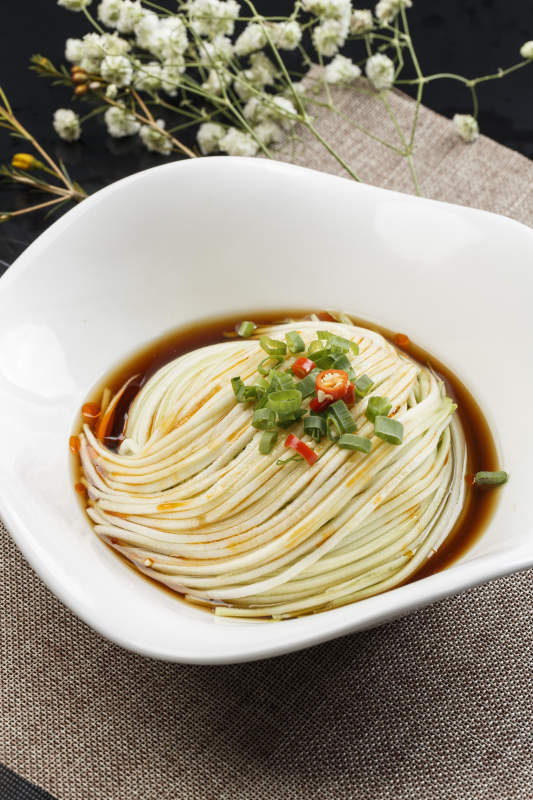 花型白瓷盘装的捞汁瓜丝-摄影图