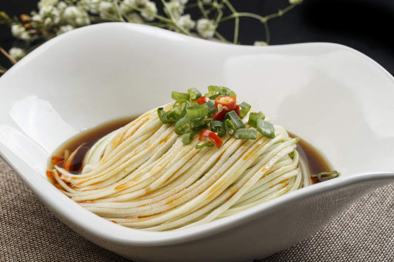 花型白瓷盘装的捞汁瓜丝-摄影图