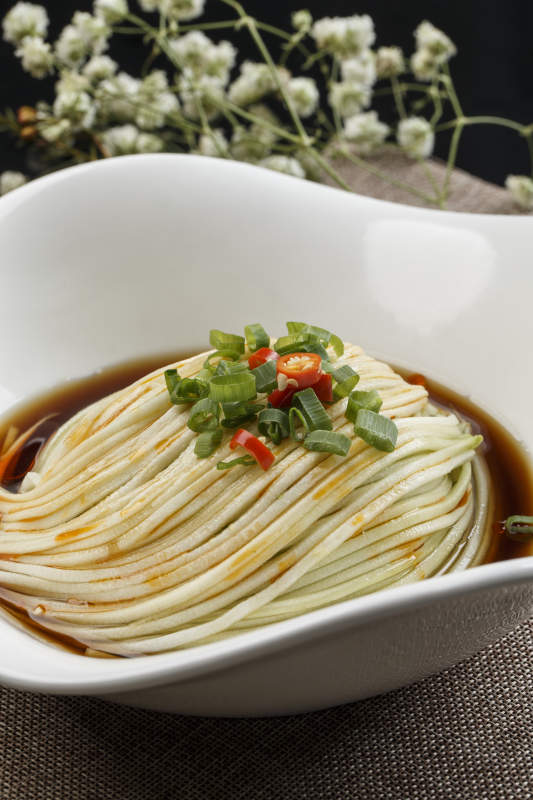 花型白瓷盘装的捞汁瓜丝-摄影图