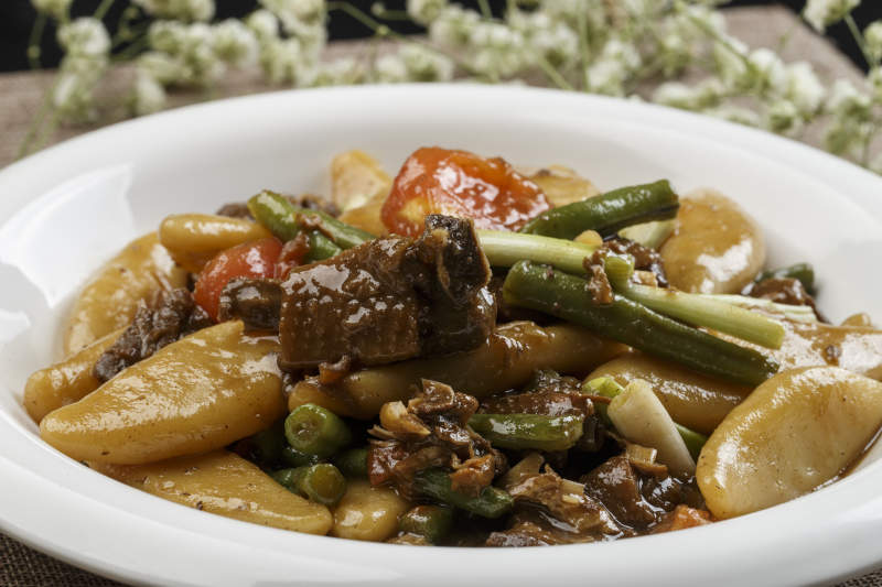 白色瓷盘装的豆角红烧肉炖山药鱼