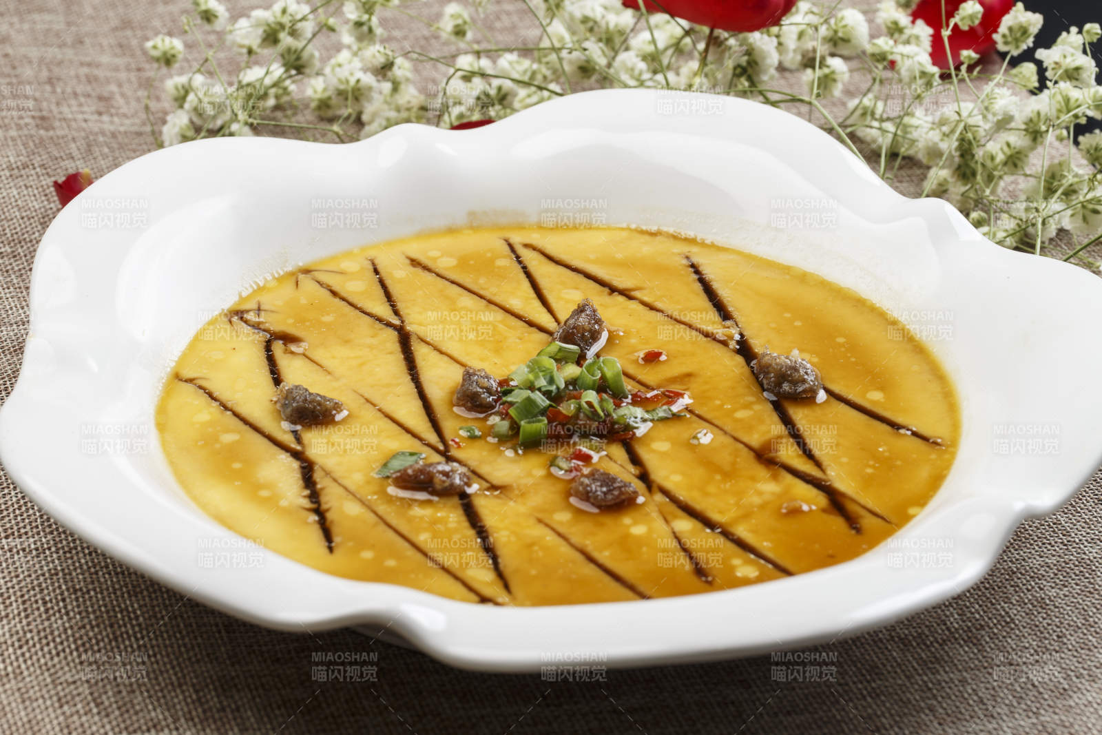 白色瓷盘装的蛤肉海鲜汁蒸水蛋