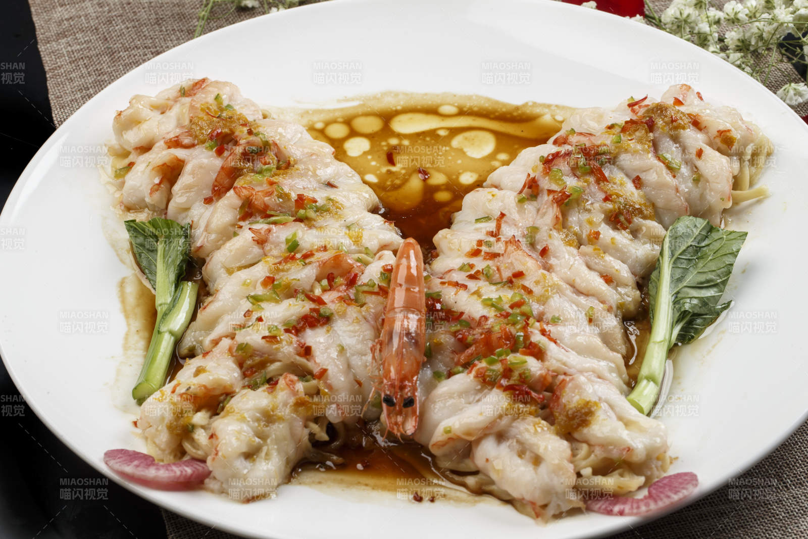 白色瓷盘装的浇汁蒜蓉蝴蝶虾