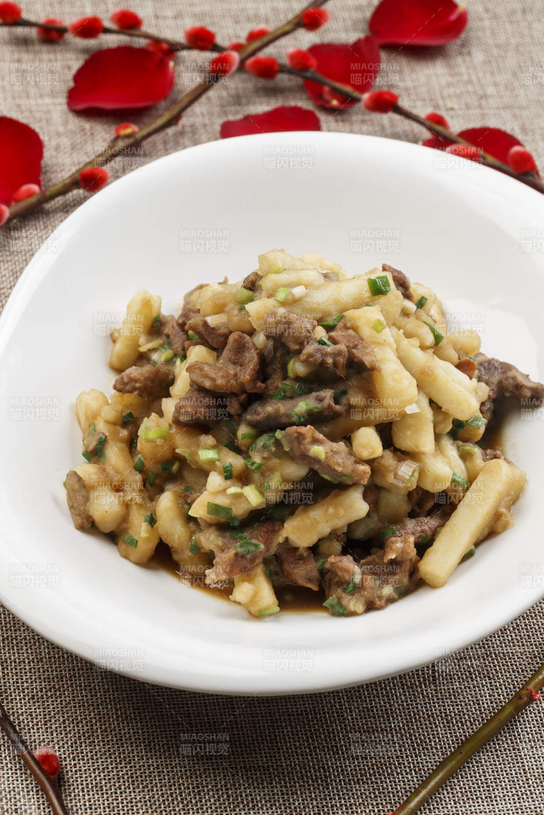 白色瓷盘装的葱香土豆烧牛肉