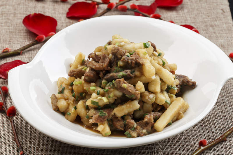 白色瓷盘装的葱香土豆烧牛肉