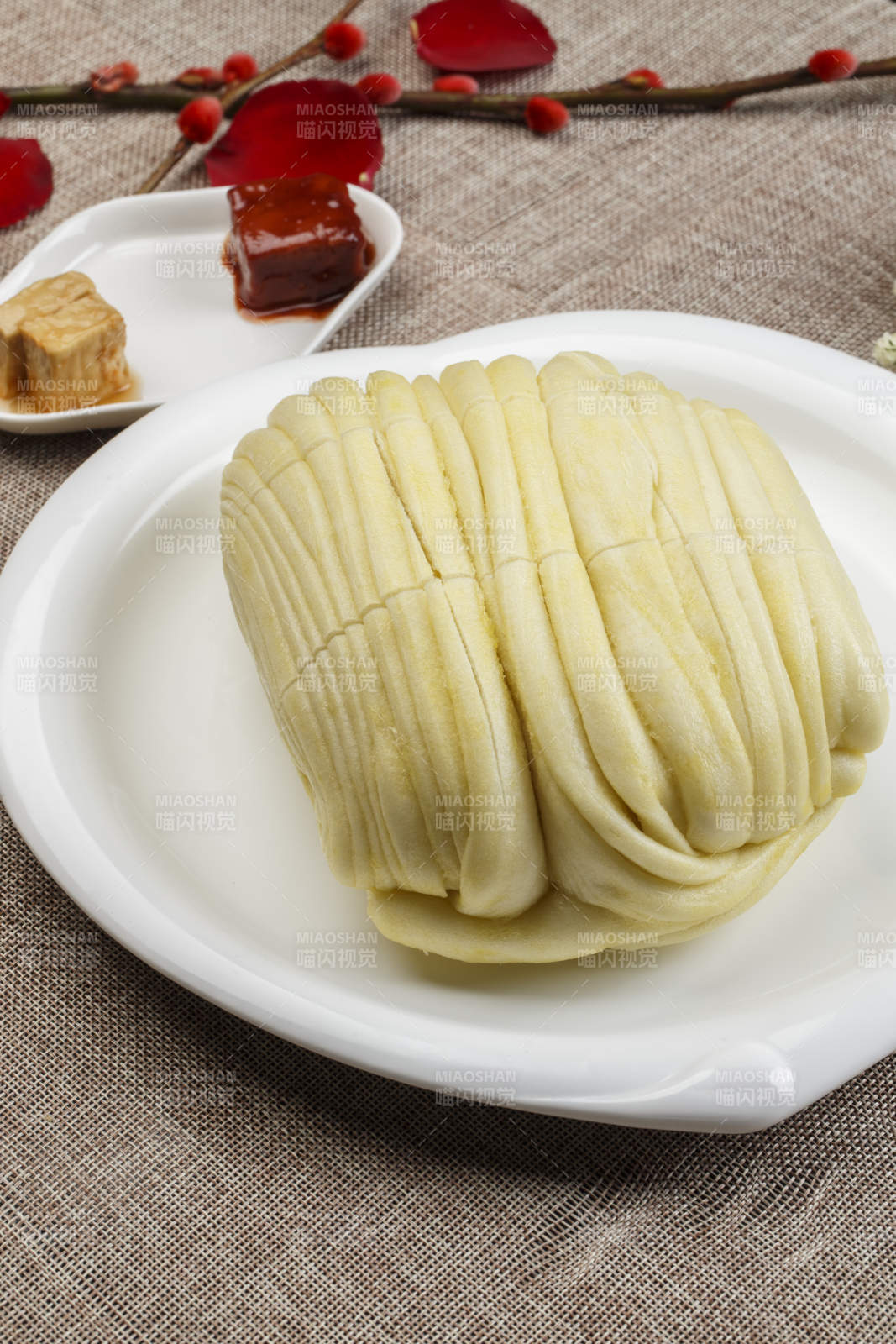 白色瓷盤裝的現(xiàn)蒸麻油大花卷