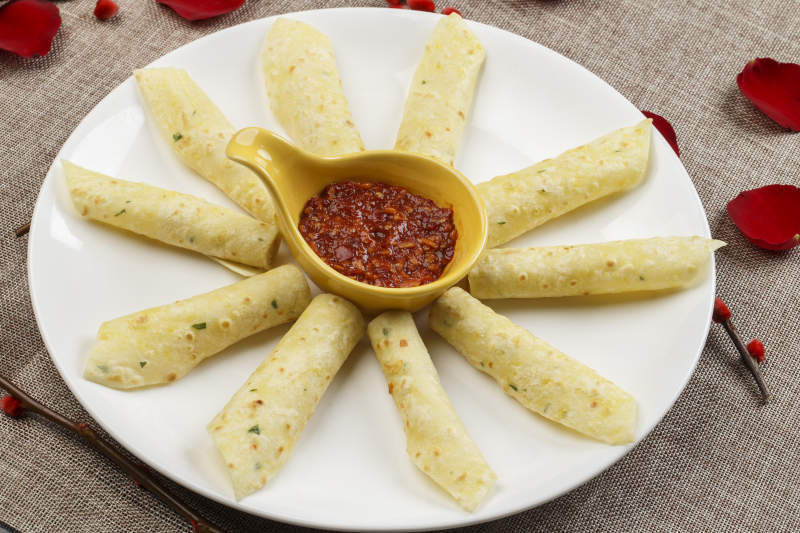 白色瓷盘装的蘸酱玉米饼