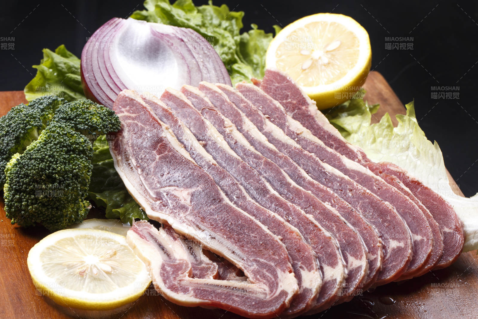 搭配柠檬洋葱生菜的牛肋排摆放在木质砧板上