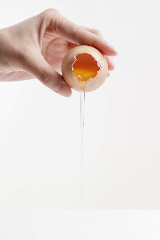 手中的开口油鸡蛋将蛋清倒出