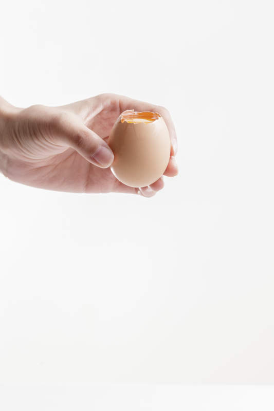 手中的开口油鸡蛋将蛋清倒出