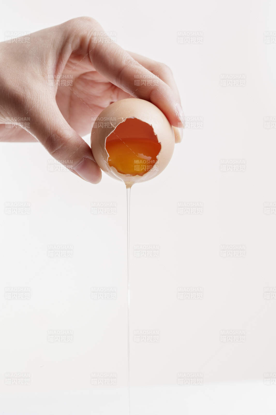 手中的开口油鸡蛋将蛋清倒出