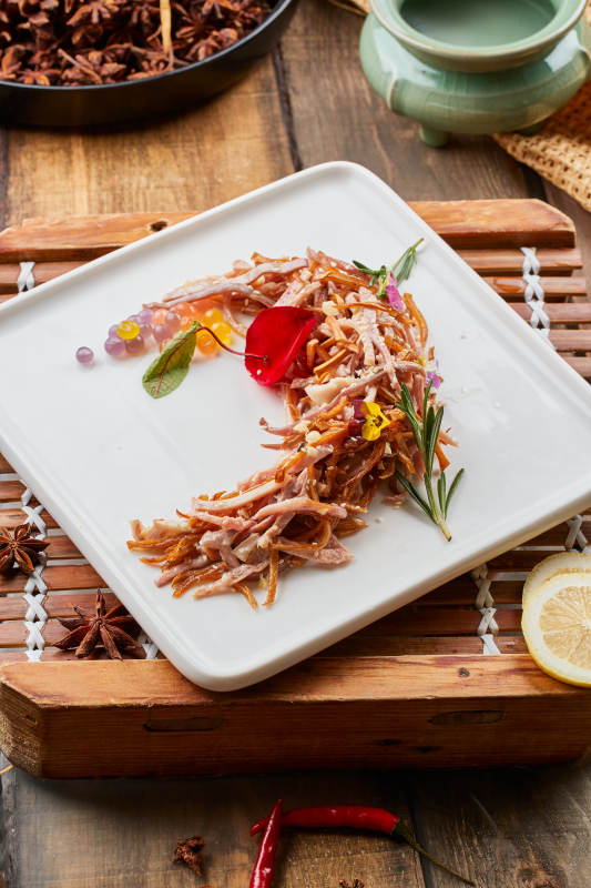 陳舊木板上的方瓷盤裝的風味手撕兔