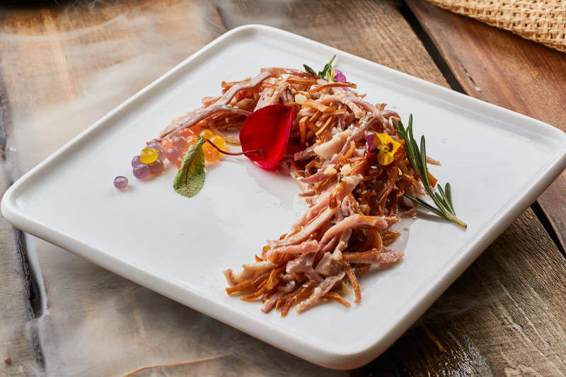 陳舊木板上的方瓷盤裝的風味手撕兔