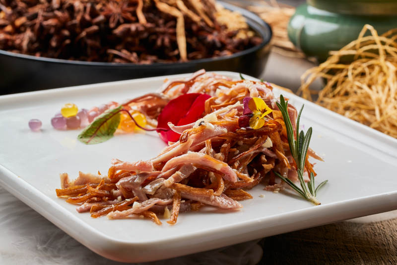 陳舊木板上的方瓷盤裝的風味手撕兔