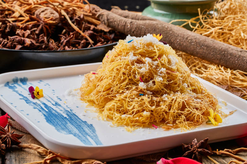 陈旧木板上的方瓷盘装的撒糖一窝丝-摄影图