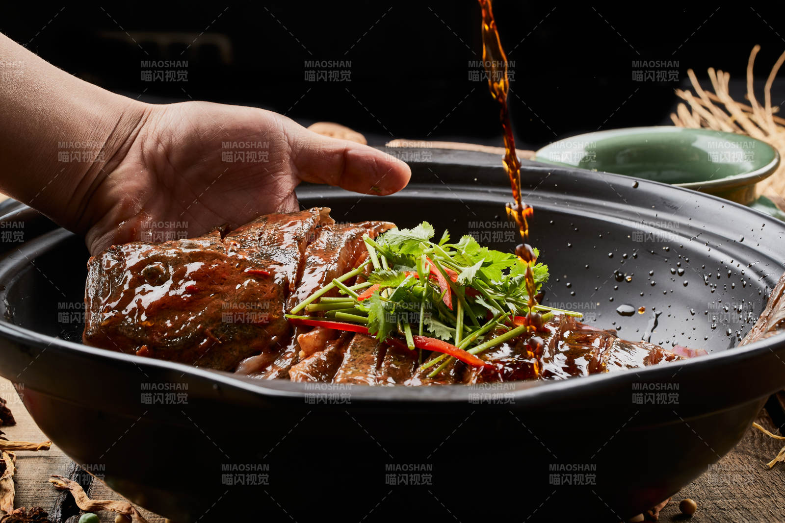 陈旧木板上的黑色砂锅装的浓汤生噘鲽鱼