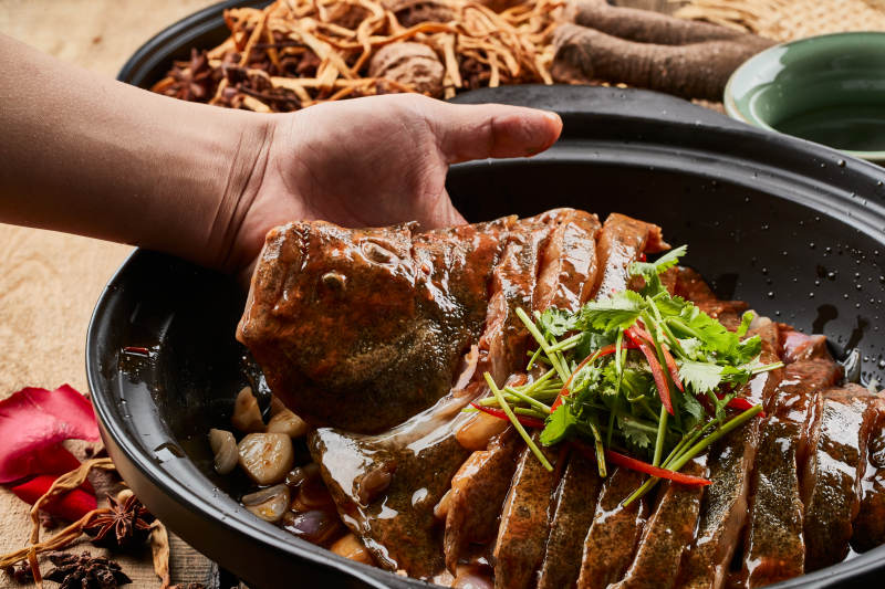 陈旧木板上的黑色砂锅装的浓汤生噘鲽鱼