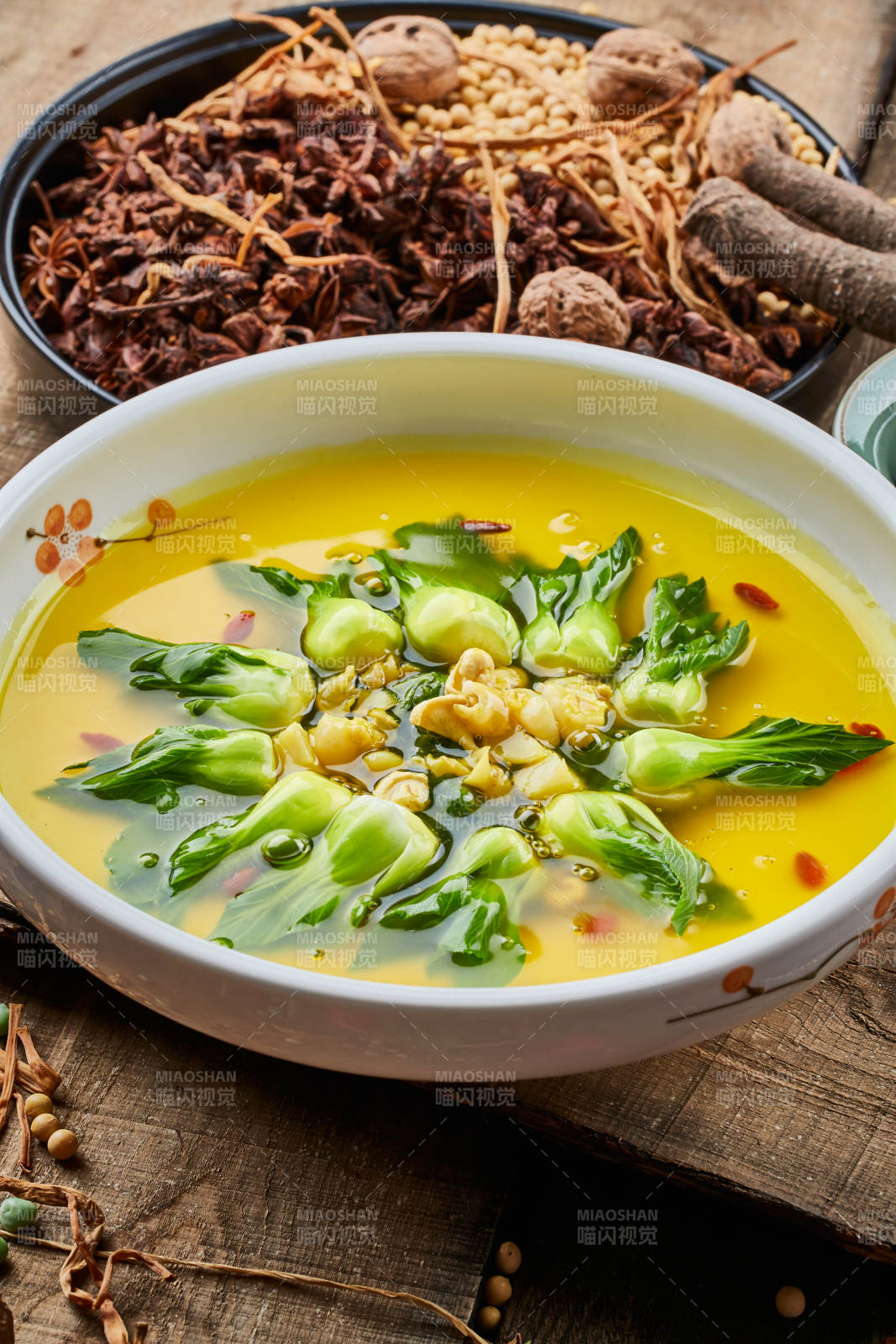 陈旧木板上的白瓷圆盘装的浓汤油菜烧菇片