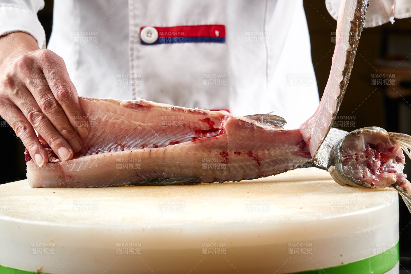 白色砧板上厨师用精湛的刀工展示生鱼片及鲜鱼料理切割分切的刀工图片