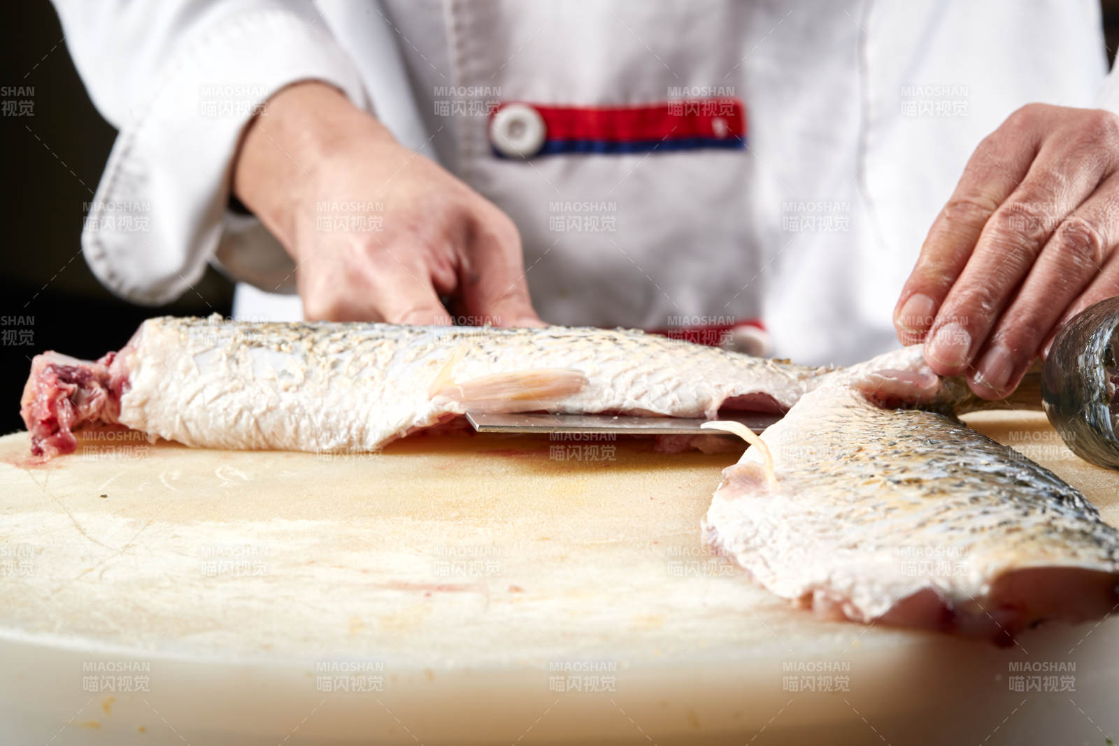 白色砧板上厨师用精湛的刀工展示生鱼片及鲜鱼料理切割分切的刀工图片