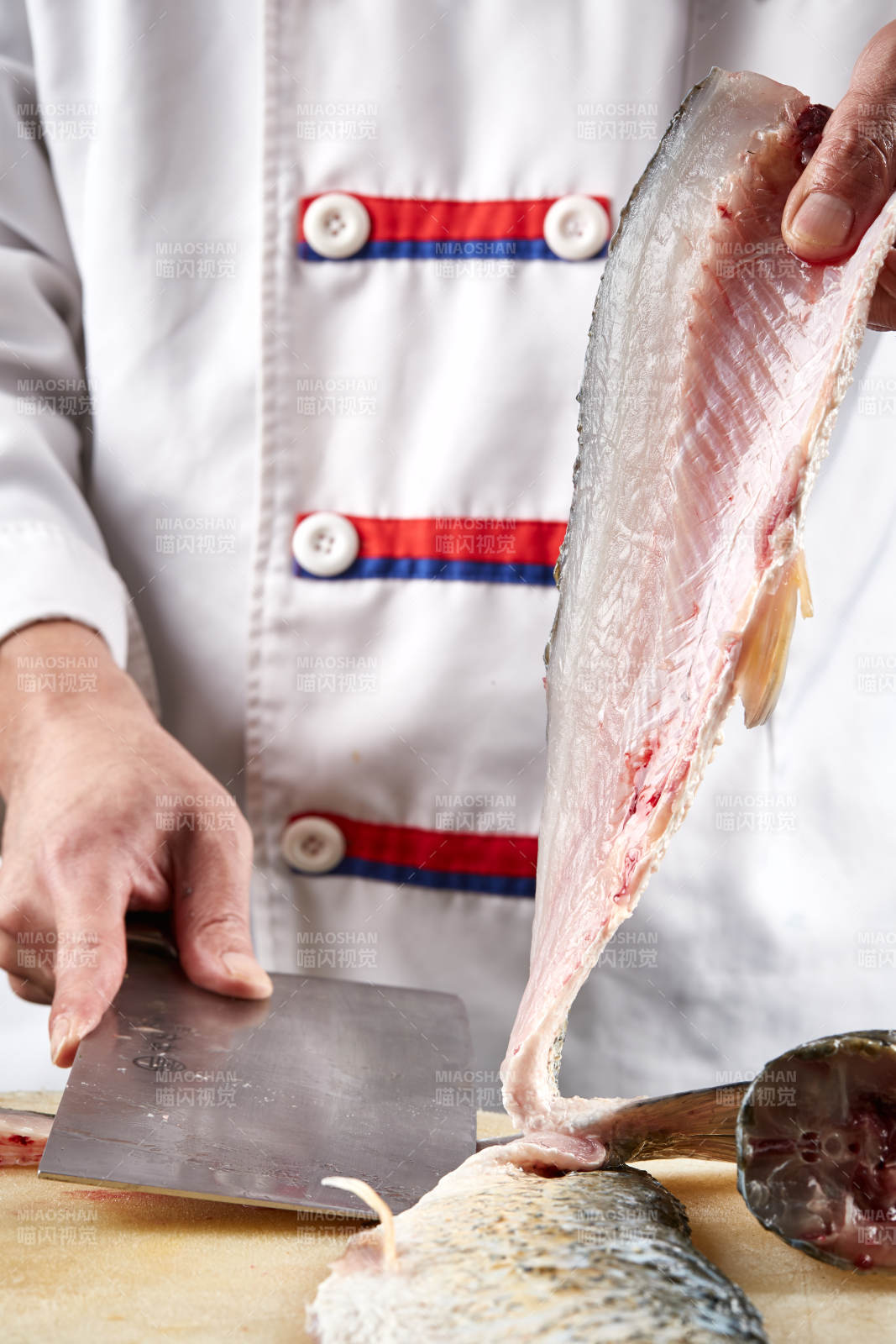 白色砧板上厨师用精湛的刀工展示生鱼片及鲜鱼料理切割分切的刀工图片