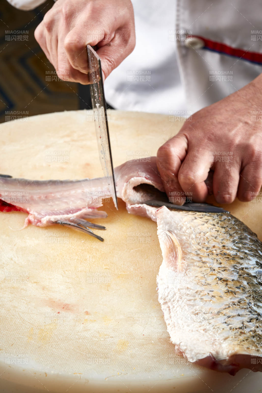 白色砧板上厨师用精湛的刀工展示生鱼片及鲜鱼料理切割分切的刀工图片