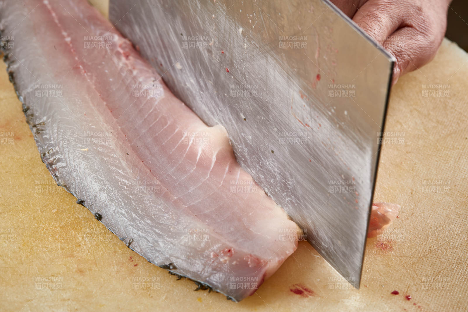 白色砧板上厨师用精湛的刀工展示生鱼片及鲜鱼料理切割分切的刀工图片