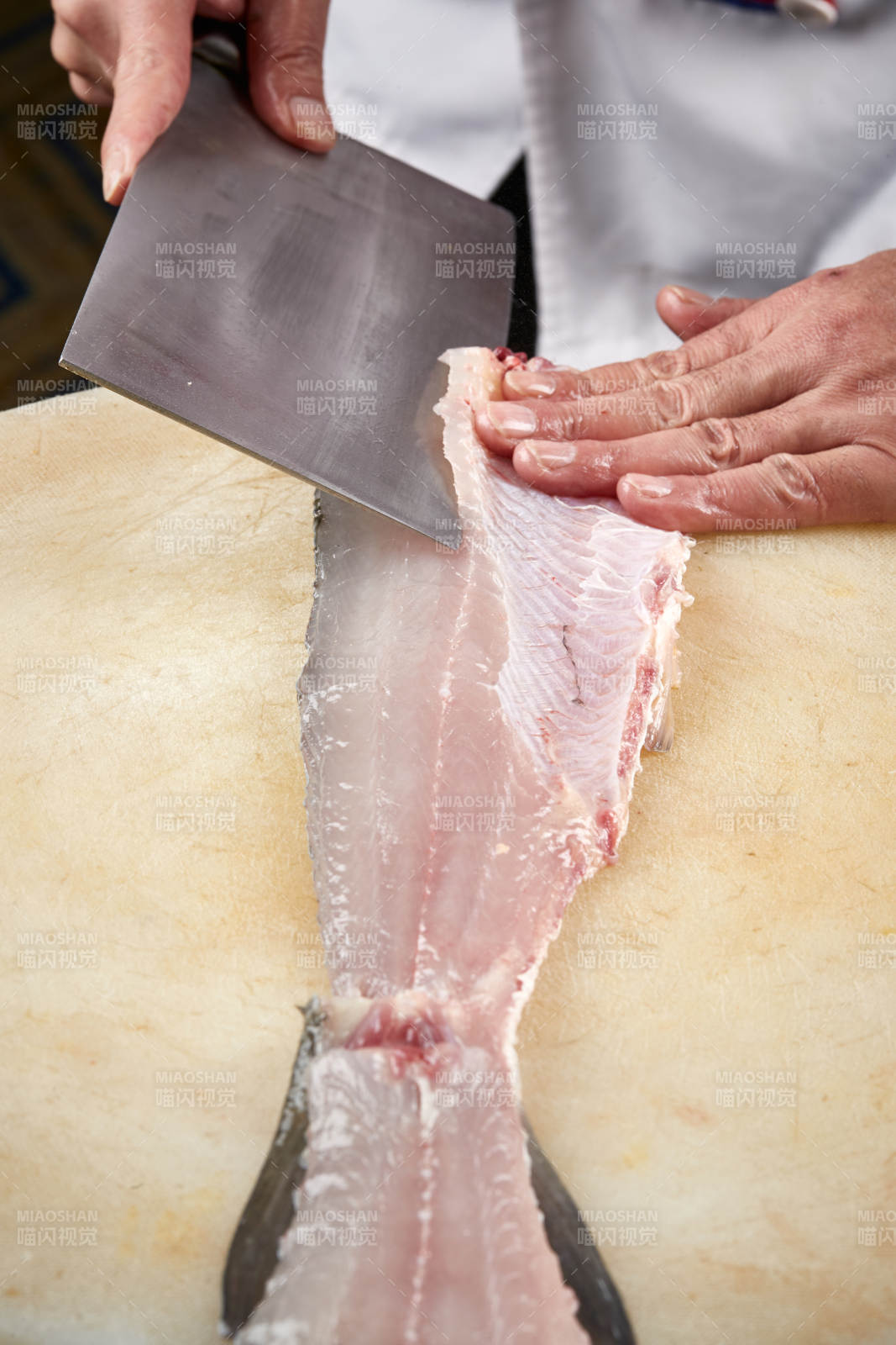 白色砧板上厨师用精湛的刀工展示生鱼片及鲜鱼料理切割分切的刀工图片