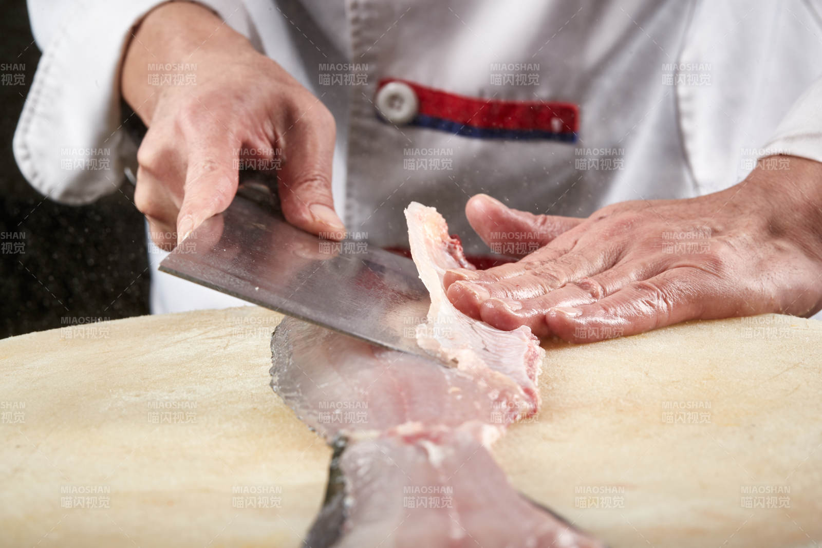 白色砧板上厨师用精湛的刀工展示生鱼片及鲜鱼料理切割分切的刀工